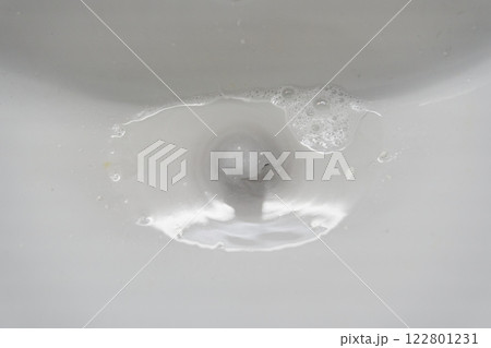 White ceramic bathroom sink with water that goes down the drain. With space to copy. High quality photo 122801231