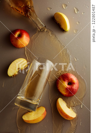 Apple juice is poured into a glass. Apple juice is poured into a glass. 122801487