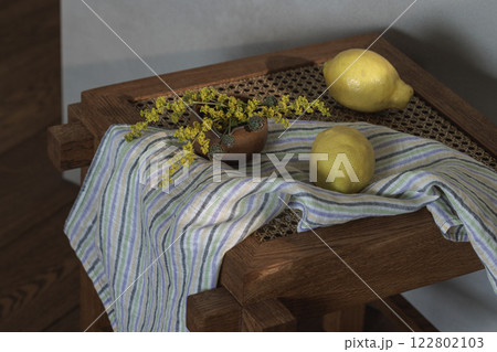 Fresh lemons and yellow wild flowers on wood rattan stool. Home decoration concept 122802103