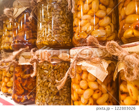 Jars of honey filled, with various nuts and seeds, are displayed on the store shelf, no people, mobile photo, 122803026