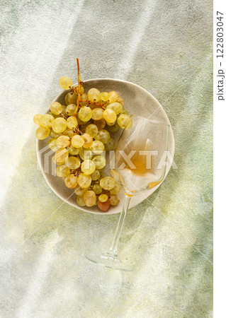 a branch of white grapes, on a gray plate, with a glass of white wine, top view, natural light, food concept, no people, a branch of white grapes, on a gray plate, with a glass of white wine, top view, natural light, food concept, no people, 122803047