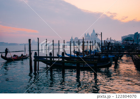 Sunset Over the Beautiful Venetian Canals with Charming Gondolas Gliding by Sunset Over the Beautiful Venetian Canals with Charming Gondolas Gliding by 122804070