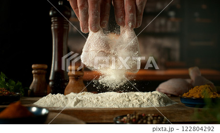 Freeze Motion of Hitting Raw Chicken Legs Covered with Flour . Closeup of Meat Preparation Freeze Motion of Hitting Raw Chicken Legs Covered with Flour . Closeup of Meat Preparation 122804292