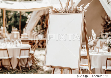Wedding welcome sign, blank mockup on an easel at an outdoor boho rustic event. 122804566