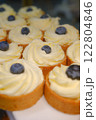 beautiful white cheesecake tart with fresh blueberries in shortcrust pastry basket placed on a white plate on the counter perfect dessert for a bakery or cafe sweet indulgence for food photography 122804846