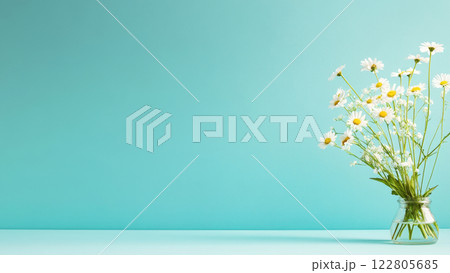 Delicate spring flowers arranged in a glass vase on a pastel blue surface with copy space for text Delicate spring flowers arranged in a glass vase on a pastel blue surface with copy space for text 122805685