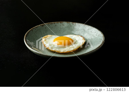 fried eggs in the shape of a heart on a dark background 122806613