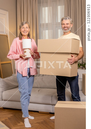 Mature couple moving to new apartment and unpacking cardboard boxes 122806913