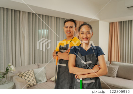 Cheerful Professionals Wearing Aprons Posing Together in a Modern Living Room Cheerful Professionals Wearing Aprons Posing Together in a Modern Living Room 122806956