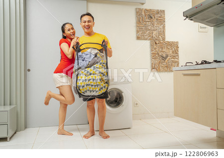 A Couple Happily Enjoying Household Chores Together in a Cozy Laundry Room Space A Couple Happily Enjoying Household Chores Together in a Cozy Laundry Room Space 122806963