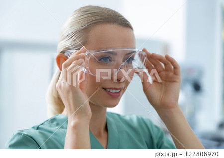 Professional woman biologist wearing safety glasses working in laboratory 122806970