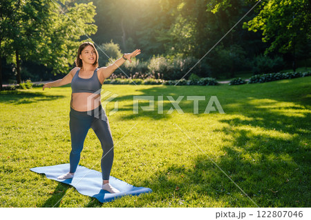 Young pregnant woman standing in a warrior pose and looking confident Young pregnant woman standing in a warrior pose and looking confident 122807046