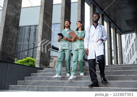 Group of doctors in lab coats feeling confident and looking determined 122807301
