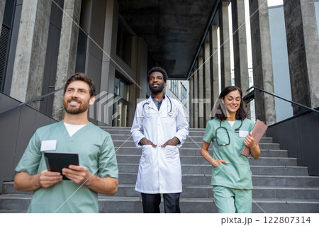Young healthcare workers on the clinic steps going down Young healthcare workers on the clinic steps going down 122807314