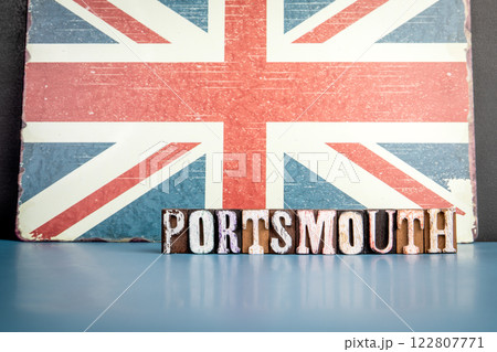 PORTSMOUTH. Urban Area in Great Britain. Flag and alphabet letters on wooden texture background 122807771