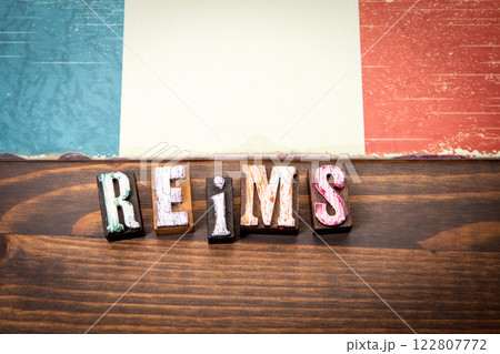 REIMS. Flag and alphabet letters on wooden texture background 122807772