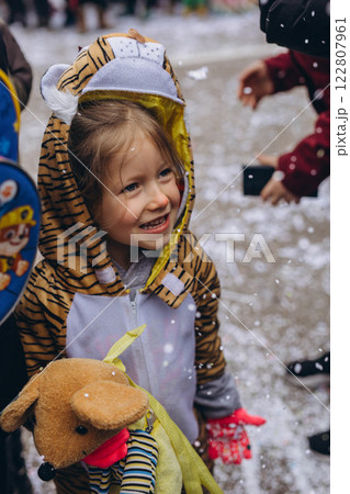 5-year-old girl in a tiger costume at a carnival in Germany, full of joy and excitement. 122807961