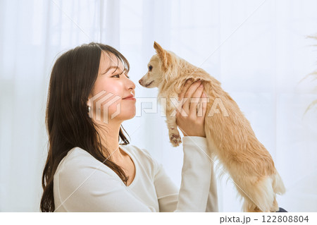 リビングで愛犬と遊ぶ女性 122808804