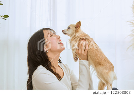 リビングで愛犬と遊ぶ女性 122808808