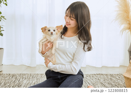 リビングで愛犬と遊ぶ女性 122808815