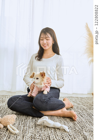 リビングで愛犬と遊ぶ女性 リビングで愛犬と遊ぶ女性 122808822
