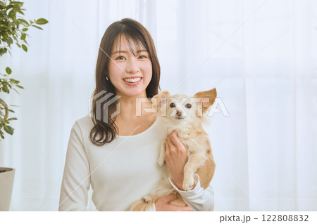 リビングで愛犬と遊ぶ女性 122808832