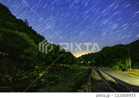 山里の小川に舞うホタルと星の軌跡 122808933