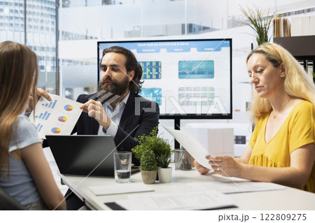 Financial advisor showing clients forex trends charts, diagrams and economic indicators. Broker using large display to present mom and gen Z girl strategies to identify investment opportunities Financial advisor showing clients forex trends charts, diagrams and economic indicators. Broker using large display to present mom and gen Z girl strategies to identify investment opportunities 122809275