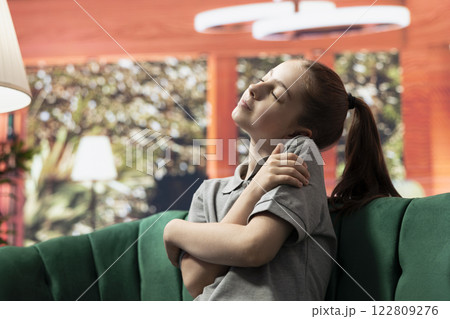 Young teen hugging herself to show self appreciation and a positive image of herself, improve her self esteem and confidence. Independent girl makes progress for self acceptance. Self care. Young teen hugging herself to show self appreciation and a positive image of herself, improve her self esteem and confidence. Independent girl makes progress for self acceptance. Self care. 122809276