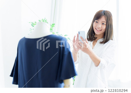 スマートフォンで衣服の撮影をする女性 122810294