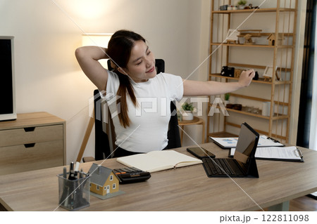 young businesswoman is stretching her body to relieve fatigue from working young businesswoman is stretching her body to relieve fatigue from working 122811098