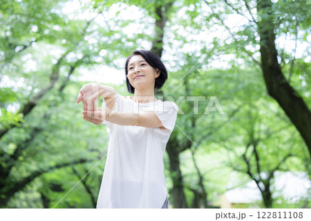 公園でストレッチをしているミドル女性 122811108