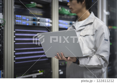 サーバエンジニアイメージ　ノートパソコンで作業をする若い男性の手元 122811212