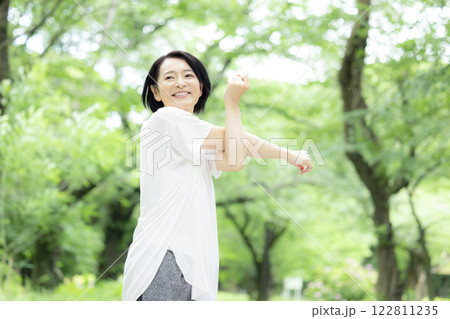 公園でストレッチをしているミドル女性 公園でストレッチをしているミドル女性 122811235
