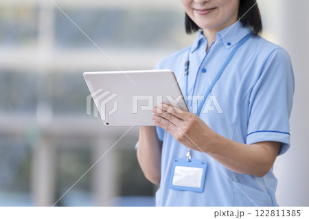 タブレットを操作する施設スタッフの手元 イメージ 122811385