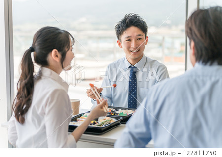 社員食堂でランチ・仕出し弁当・デリバリー・ケータリングの弁当を食べる男女（福利厚生） 122811750