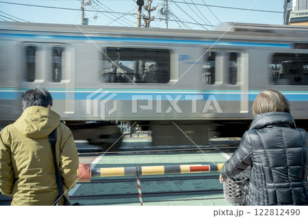 踏切で待つ人々 122812490