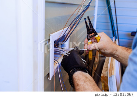 Contractor electrician uses tools to connect wires while during electrical work. 122813067