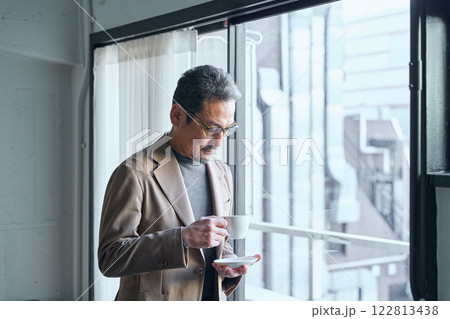 窓際でコーヒーを飲む男性 122813438