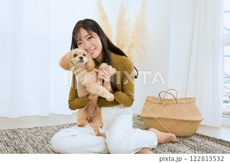 リビングで愛犬と遊ぶ女性 122813532