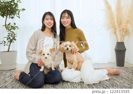 リビングで愛犬と遊ぶ女性 122813585