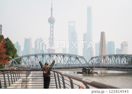 woman traveler visiting in Shanghai, China. Happy Female Tourist sightseeing Oriental Pearl Tower and Waibaidu Bridge view. landmark and popular for tourism attractions. Travel and vacation concept 122814543