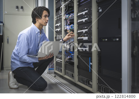 パソコンを持って作業をするITエンジニア 122814800