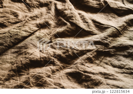 Crumpled brown natural linen fabric 122815634