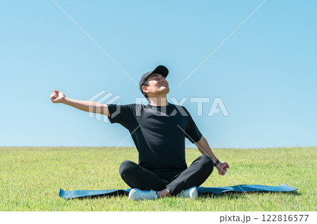 公園でリフレッシュをする男性(運動・ピラティス・ワークアウト・ヨガ・スポーツ) 122816577