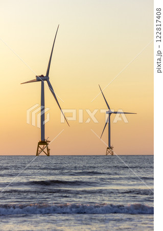 夕日に照らされる風力発電機 122817408