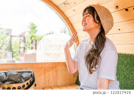 サウナに入っているサウナハットを被った若いアジア人女性 122817419