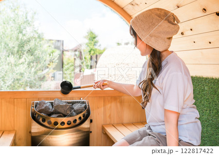 サウナに入っているサウナハットを被った若いアジア人女性 サウナに入っているサウナハットを被った若いアジア人女性 122817422