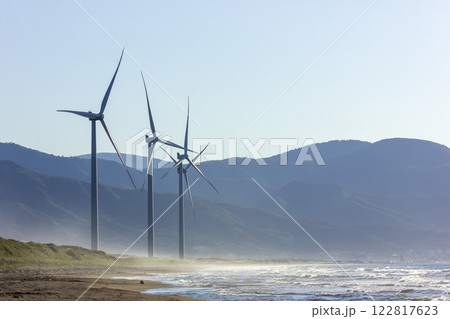 夕暮れの海岸線に立つ風力発電機 122817623