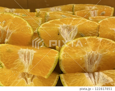 4分の1にカットされた緑色の皮がついたみかん 122817851